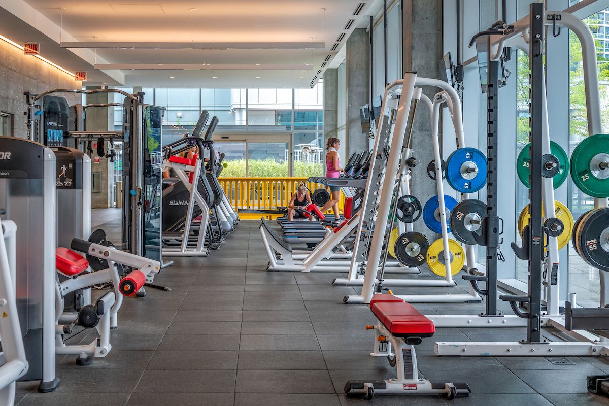 Optima Signature in Downtown Chicago with Modern gym with exercise machines, free weights, and people working out—ideal for anyone pursuing an effortless wellness routine.