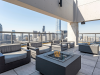 Optima Signature in Downtown Chicago with Modern Optima rooftop lounge with gray seating, fire tables, and city skyscrapers in the background creates an inviting outdoor space.