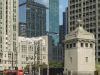 Optima Signature in Downtown Chicago with A man stands on a city bridge, reflecting on the value of commute, with tall skyscrapers and the Chicago Tribune building behind him.