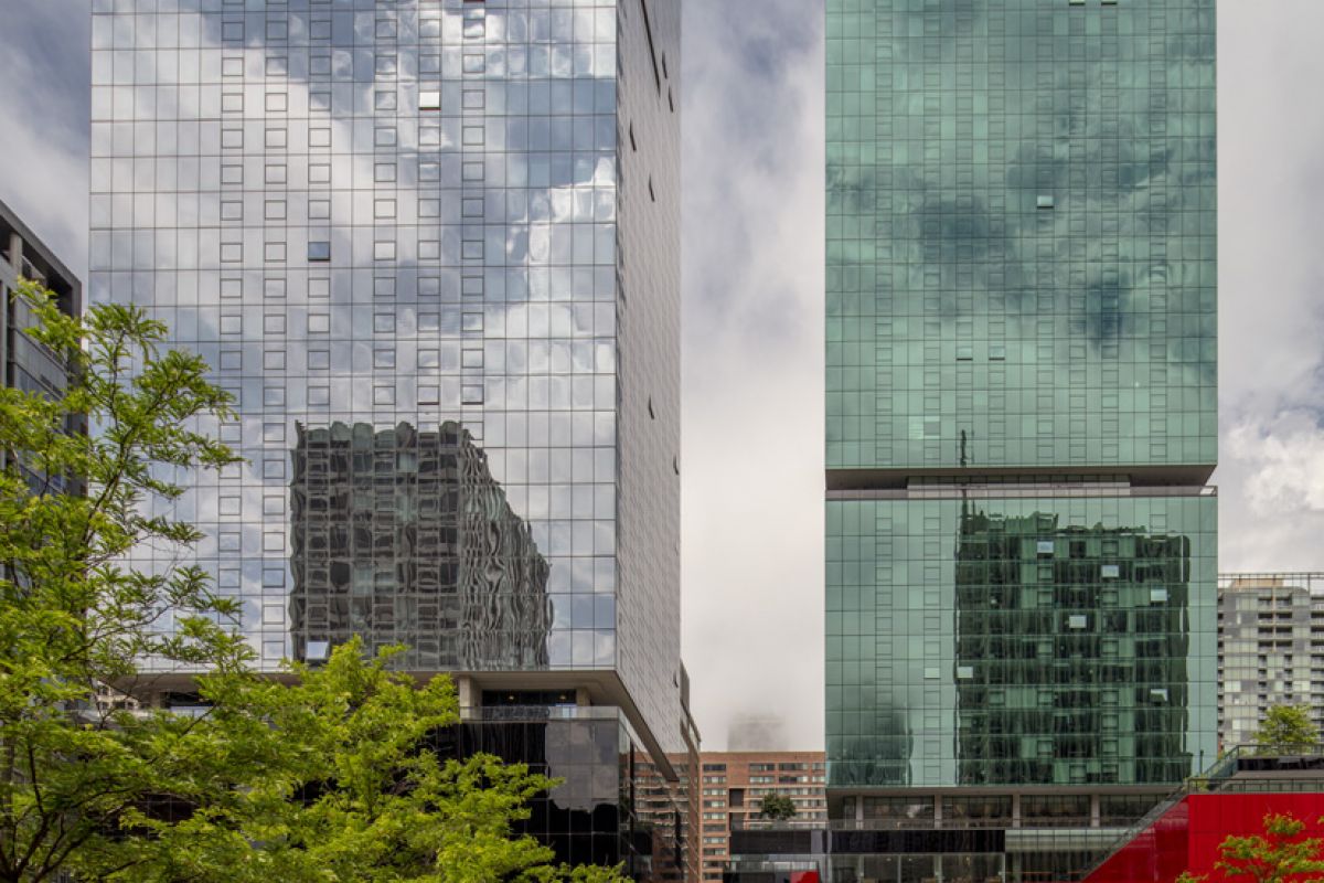 Optima Signature in Downtown Chicago with Two tall glass skyscrapers with reflections stand behind a green park, illustrating optimized service in an urban oasis under a partly cloudy sky.