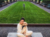 Optima Signature in Downtown Chicago with Woman in light clothes sits with her dog in a pet-friendly city park near Optima Signature, surrounded by tall glass buildings and trees.