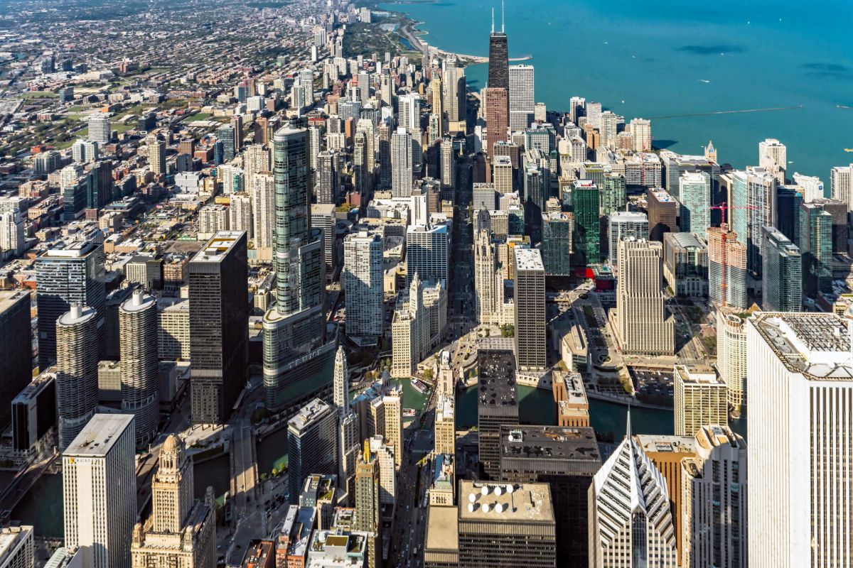 Optima Signature in Downtown Chicago with Aerial view of downtown Chicago with tall skyscrapers, Lake Michigan, and vibrant urban lifestyle in the background.