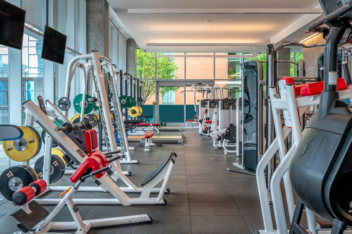 Optima Signature in Downtown Chicago with Modern fitness center with various weight machines, benches, and free weights in a bright, spacious room with large windows—ideal for your daily habit.