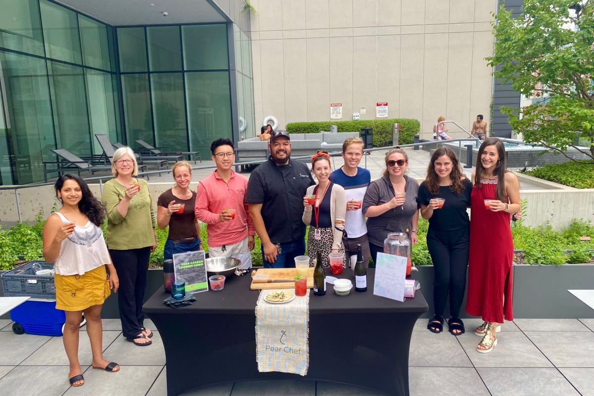Optima Signature in Downtown Chicago with Members of the Optima Community enjoy daily life, smiling around a table with drinks outdoors.
