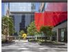 Optima Signature in Downtown Chicago with Modern city plaza with trees, Art, a yellow abstract sculpture, and glass buildings—one with a bold red facade and Optima's Lobbies.