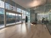 Optima Signature in Downtown Chicago with Modern gym room at Optima Signature with wooden floors, glass walls, treadmills, and yoga or Pilates space overlooking the urban patio.