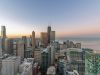 Optima Signature in Downtown Chicago with Aerial view of Optima Signature city skyline at sunrise, with high-rise buildings and a calm lake reflecting biophilic design principles.