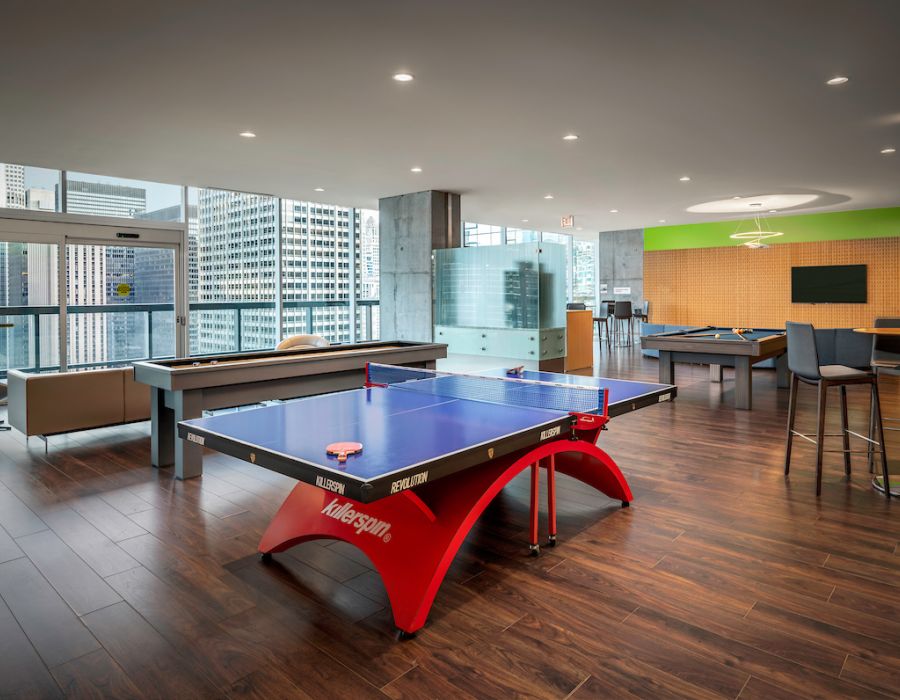 Optima Signature in Downtown Chicago with Modern lounge with table tennis, pool table, seating areas, and large windows overlooking city skyscrapers.