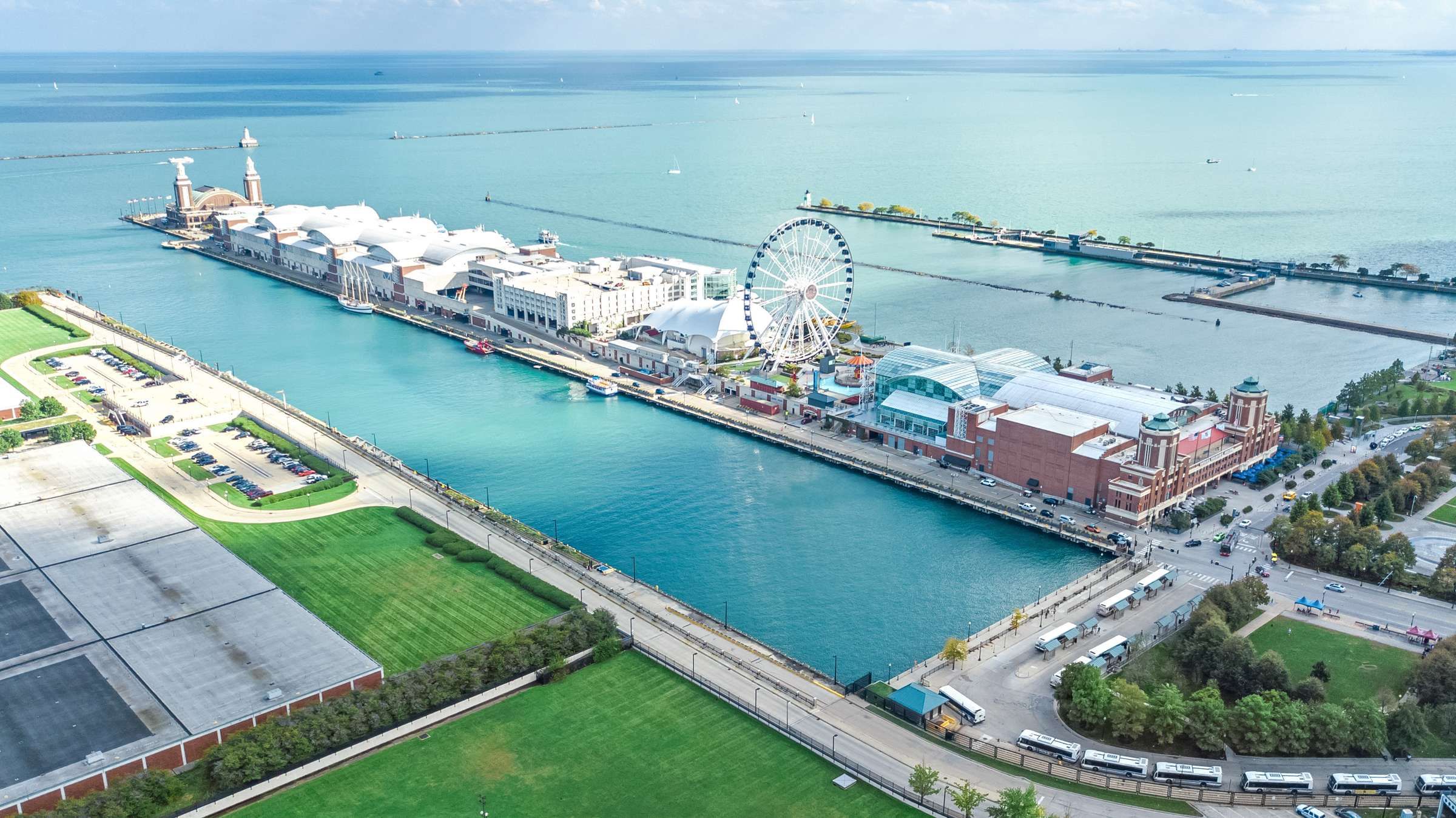 Optima Signature in Downtown Chicago with Aerial view of Navy Pier in Chicago with a Ferris wheel, buildings, and Lake Michigan in the background.