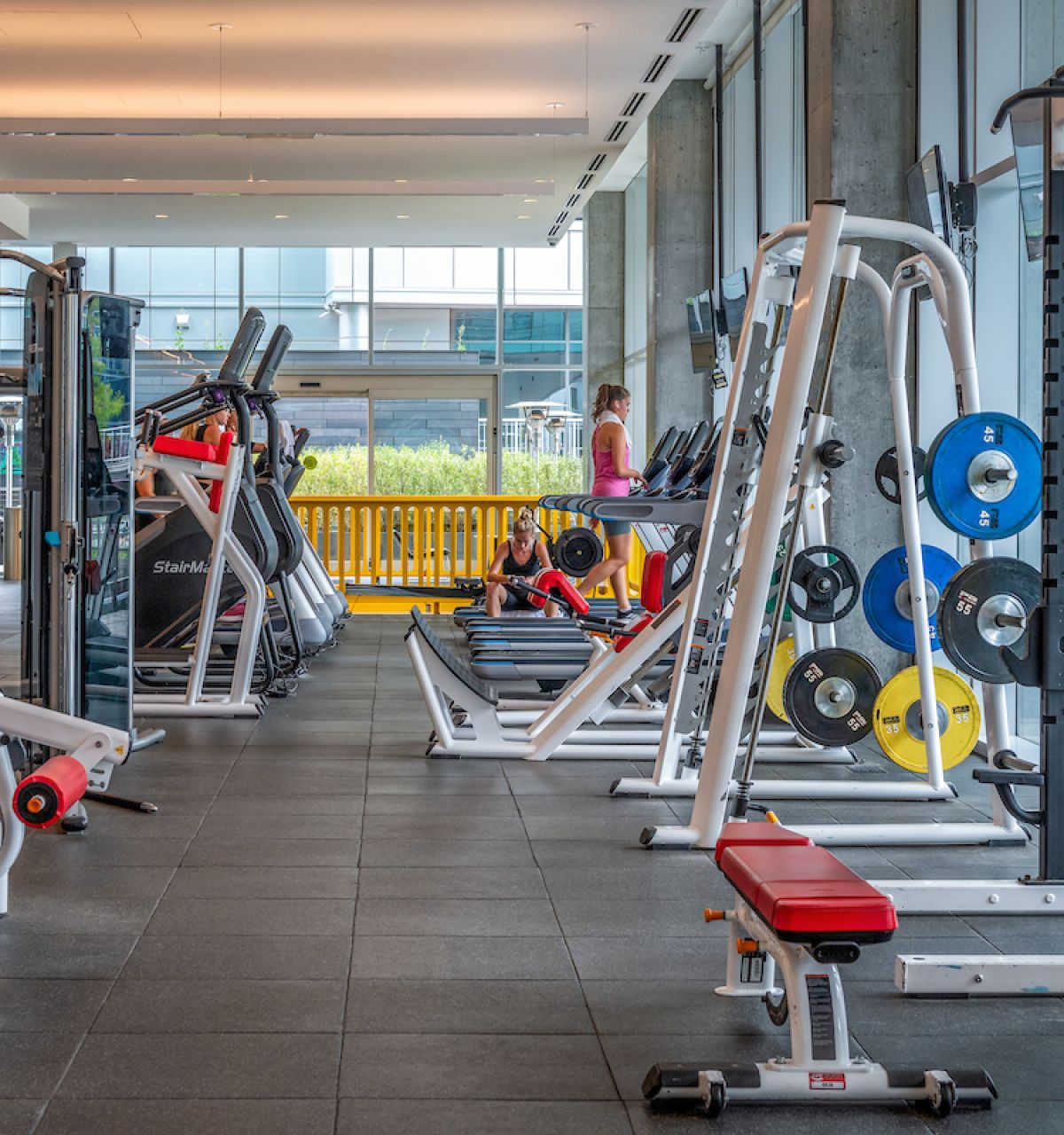 Optima Signature in Downtown Chicago with Modern gym with exercise machines, free weights, and people working out—ideal for anyone pursuing an effortless wellness routine.