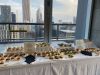 Optima Signature in Downtown Chicago with A table with many small food dishes is set up on a balcony at Optima Connect, offering perks like menus and candles above city skyscrapers.