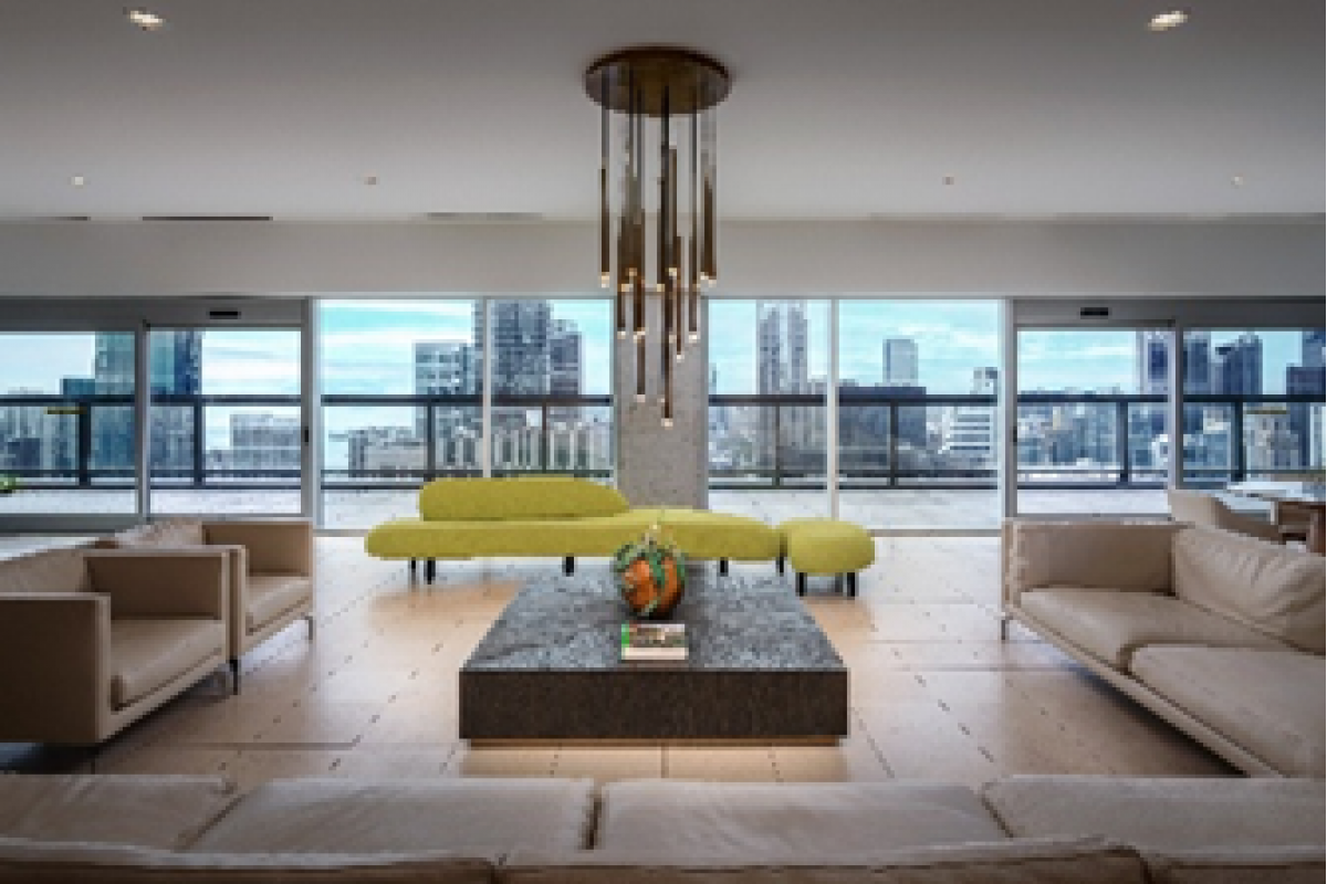 Optima Signature in Downtown Chicago with Modern living room with beige sofas, green seating, a central table, and large windows—ideal for a stylish Optima designs home office.