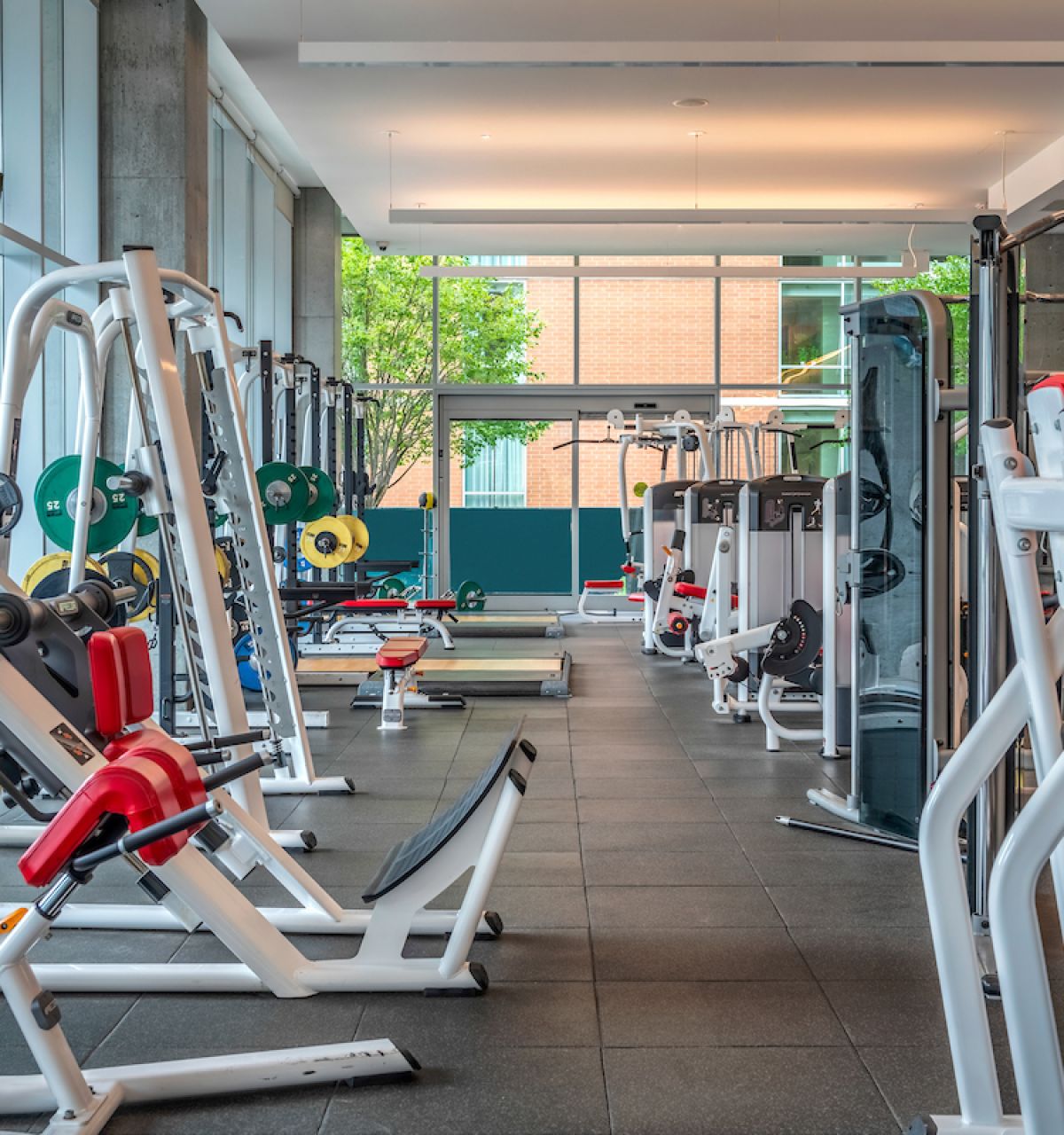 Optima Signature in Downtown Chicago with Modern fitness center with various weight machines, benches, and free weights in a bright, spacious room with large windows—ideal for your daily habit.