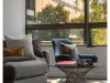 Optima Signature in Downtown Chicago with Modern living room featuring Optima furniture—a gray sofa, blue armchair, round coffee table, and large window with outdoor view.