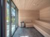 Optima Signature in Downtown Chicago with Modern wooden sauna with tiered benches, rocks heater, and Optima Signature Recovery Circuit, overlooking an urban area.