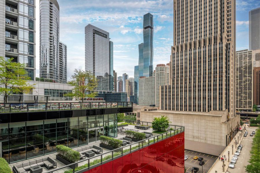 Optima Signature in Downtown Chicago with Modern city skyline with tall skyscrapers, glass buildings, and a terrace with greenery in the foreground.