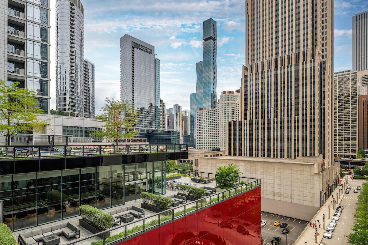 Optima Signature in Downtown Chicago with Modern cityscape with tall skyscrapers, outdoor terraces, and biophilic design elements beneath a partly cloudy sky.