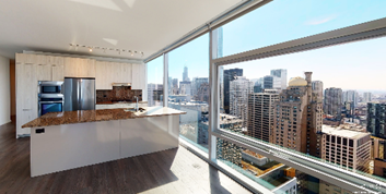 Optima Signature in Downtown Chicago with Modern kitchen at Optima Signature featuring large windows and city skyline views on a sunny day.