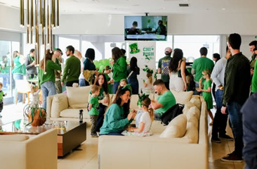 Optima Signature in Downtown Chicago with A group of people, many in green, gather in a bright room decorated for a cheerful celebration.