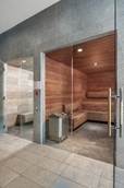 Optima Signature in Downtown Chicago with Modern steam room with wooden benches, a glass door, and tiled floors, located in a spa or gym setting.