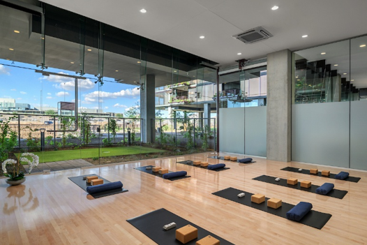 Optima Signature in Downtown Chicago with A modern yoga studio with mats, blocks, and bolsters on a wooden floor, large glass windows, and a garden view.